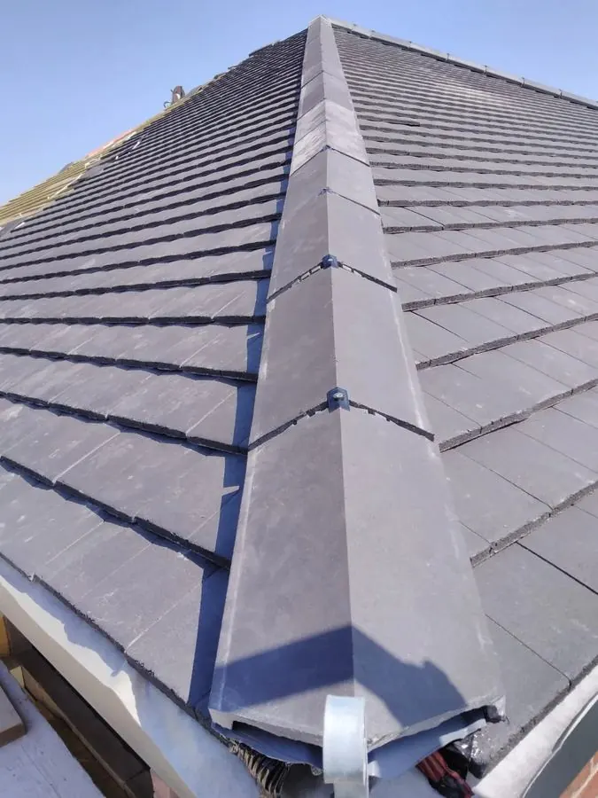 Close-up of slate shingle roof with metal ridge cap