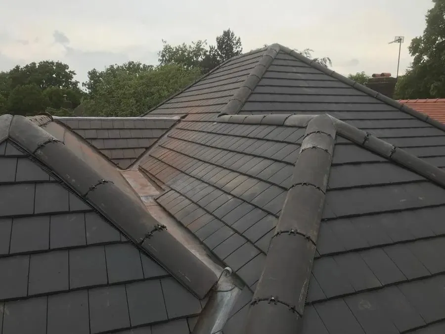 Close-up of black tiled roof with multiple slopes